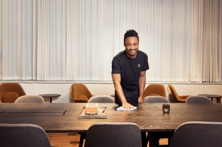 Schoonmaakmedewerker aan het werk in een vergaderruimte