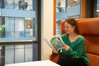 Een vrouw die Smarter Worklife Magazine leest