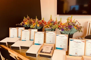 Een foto van awards, bloemen en certificaten