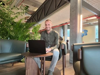 een lachende man met laptop