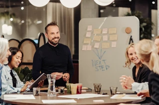 Projectmeeting met meerdere lachende mensen