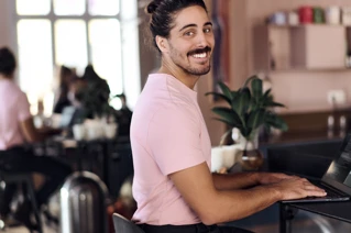 Een lachende man met laptop