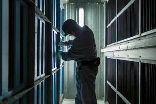 Een man in overall wisselt filters in een paintcabine