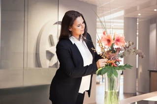 Receptioniste die bloemen in een vaas steekt